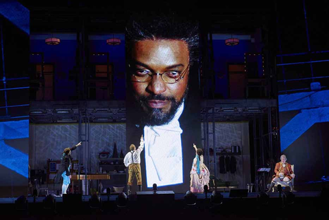 A scene from Rossini's "The Barber of Seville" with Kenneth Kellogg as Basilio (on screen) with Alek Shrader as Almaviva, Lucas Meachem as Figaro, Daniela Mack as Rosina and Philip Skinner as Dr. Bartolo.  Photo: Stefan Cohen