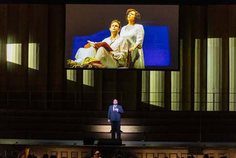 San Francisco Opera's "100th Anniversary Concert" with Brian Mulligan performing an aria from John Adams' "Doctor Atomic" below an archival San Francisco Opera historic image (the 2005 world premiere of "Doctor Atomic" with Gerald Finley and Kristine Jepson). Photo: Drew Altizer Photography